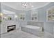 Spacious bathroom with marble floors, white vanity with makeup table, soaking tub, and chandelier at 12848 Jacob Grace Ct, Windermere, FL 34786