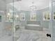 A large, bright bathroom featuring marble floors, chandelier, and a glass-enclosed shower at 12848 Jacob Grace Ct, Windermere, FL 34786