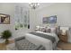This relaxing bedroom features a large window, chandelier, and neutral-colored walls at 12848 Jacob Grace Ct, Windermere, FL 34786