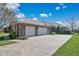 Charming home featuring a three-car garage, stone accents, and a spacious paved driveway at 12848 Jacob Grace Ct, Windermere, FL 34786