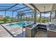 Outdoor kitchen with a built-in bar, grill, and scenic lake views, ideal for entertaining at 12848 Jacob Grace Ct, Windermere, FL 34786