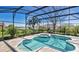 Screened pool and spa with lush landscaping, offering privacy and a tranquil view of the water at 12848 Jacob Grace Ct, Windermere, FL 34786
