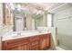 Bathroom boasts dual sinks, marble countertop, wood cabinets, and wallpaper at 1321 Medinah Ct, Winter Park, FL 32792