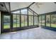 Enclosed sunroom featuring tiled floors and an abundance of windows with backyard views at 1321 Medinah Ct, Winter Park, FL 32792
