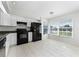 Well-lit kitchen with white cabinets, black appliances, granite counters, and a breakfast nook area at 13254 Boulder Woods Cir, Orlando, FL 32824