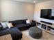 Comfortable living room featuring a plush sectional sofa, ottoman, and modern entertainment center with a television at 13727 Bressler Aly, Windermere, FL 34786