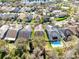 Aerial shot displays homes in a suburban neighborhood with swimming pool and other homes nearby a lake at 14225 Southern Red Maple Dr, Orlando, FL 32828