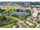 Aerial view of a mixed-use community featuring residential buildings, retail spaces, and a beautiful lake at 14225 Southern Red Maple Dr, Orlando, FL 32828