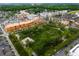 Aerial view of a mixed-use community featuring residential buildings, a park, and retail spaces at 14225 Southern Red Maple Dr, Orlando, FL 32828