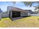 Backyard view featuring a screened-in porch and a full privacy fence at 14225 Southern Red Maple Dr, Orlando, FL 32828