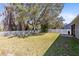 Green backyard features a mature tree, full privacy fence, and patio at 14225 Southern Red Maple Dr, Orlando, FL 32828