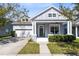 Charming two-story home featuring a covered front porch, well-maintained landscaping, and a two-car garage at 14225 Southern Red Maple Dr, Orlando, FL 32828
