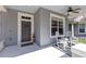 Inviting front porch featuring rocking chairs, a ceiling fan, and a decorative wreath on the front door at 14225 Southern Red Maple Dr, Orlando, FL 32828