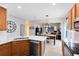 Kitchen with wood cabinets, stainless appliances, white countertops, and view to dining room and living room at 14225 Southern Red Maple Dr, Orlando, FL 32828