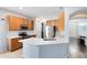 A kitchen is with stainless steel appliances, wood cabinets, white subway tile and white quartz countertops at 14225 Southern Red Maple Dr, Orlando, FL 32828