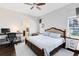 Spacious main bedroom featuring a ceiling fan, desk, and a view of the outdoors at 14225 Southern Red Maple Dr, Orlando, FL 32828