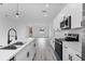 Modern open concept showing the white kitchen, stainless steel appliances, and gray floors at 16659 Sw 21St Avenue Rd, Ocala, FL 34473