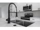 Modern kitchen sink detail with stainless steel basin, black faucet, and white countertops at 16659 Sw 21St Avenue Rd, Ocala, FL 34473