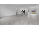 An open-concept space with modern wood floors seamlessly connecting the living area and a bright white kitchen at 16659 Sw 21St Avenue Rd, Ocala, FL 34473