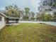 Spacious backyard with a white fence, trees and a view of the house and enclosed patio at 1730 Country Terrace Ln, Apopka, FL 32703