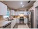 Functional kitchen featuring white cabinets, stainless steel appliances, a sink under a window, and a breakfast nook at 1730 Country Terrace Ln, Apopka, FL 32703