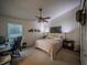 Serene main bedroom with neutral colors, a ceiling fan, carpet, and a home office setup next to a window at 1730 Country Terrace Ln, Apopka, FL 32703
