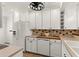 Bright kitchen featuring white cabinets, a modern refrigerator, and stylish countertops at 178 W Sabal Palm Pl # 178, Longwood, FL 32779