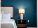 Stylish main bedroom with dark blue accent wall and matching night stand at 178 W Sabal Palm Pl # 178, Longwood, FL 32779