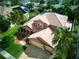 Aerial view of a terracotta-colored home with a three-car garage, tile roof, and mature landscaping at 2341 Baronsmede Ct, Winter Garden, FL 34787