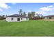 Backyard view showing the modern home's exterior and a spacious green lawn at 2480 Sw 147Th Lane Rd, Ocala, FL 34473