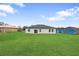 Expansive backyard featuring a well maintained lawn with home and blue skies in the background at 2480 Sw 147Th Lane Rd, Ocala, FL 34473