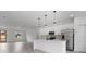 Modern open-concept living space with stylish gray floors, a sleek kitchen island, and stainless steel appliances at 2480 Sw 147Th Lane Rd, Ocala, FL 34473