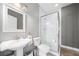 Clean bathroom featuring a pedestal sink, white tile shower, and modern fixtures at 2504 Helen Ave, Orlando, FL 32804