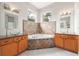 Bright bathroom featuring a soaking tub, tile surround, dual vanities, and ample natural light at 2504 Helen Ave, Orlando, FL 32804