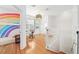 Bright hallway featuring an office nook, a desk, and access to a bedroom with rainbow decor at 2504 Helen Ave, Orlando, FL 32804