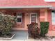 Charming single story home showcasing a peach exterior, tidy landscaping, and a welcoming front door at 2727 W Oak Ridge Rd # 5-6, Orlando, FL 32809