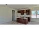 Kitchen with white walls, brown cabinets, breakfast bar, and large windows at 2953 Sailhouse Dr, St Cloud, FL 34771