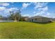 Wide backyard with lush green grass, a simple patio, and privacy fence and trees at 322 Dagama Ct, Kissimmee, FL 34758