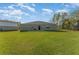 Backyard with a simple patio, lush green grass, and privacy trees at 322 Dagama Ct, Kissimmee, FL 34758