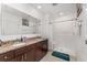 A bright bathroom with a double vanity featuring granite countertops, a large mirror, and a step-in shower at 322 Dagama Ct, Kissimmee, FL 34758