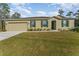 Charming single-story home with a well-manicured lawn, attached garage, and beautiful green shutters at 322 Dagama Ct, Kissimmee, FL 34758