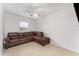 Bright living room with a brown leather sectional, ceiling fan, and neutral tile flooring creating a welcoming and comfortable space at 322 Dagama Ct, Kissimmee, FL 34758