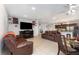 Open concept living area with a cozy electric fireplace, kitchen, and brown leather furniture at 322 Dagama Ct, Kissimmee, FL 34758