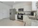 Bright kitchen features stainless steel appliances, granite counters and white cabinetry at 3270 Water Sprite St, Orlando, FL 32808