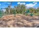 A playground is shown with swings, a slide, and wood chip ground cover surrounded by a black fence and trees at 3270 Water Sprite St, Orlando, FL 32808