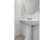 Close-up of a pedestal sink and round mirror in a half-bathroom at 3270 Water Sprite St, Orlando, FL 32808