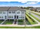Aerial view of townhouses, with well-maintained lawn, street view and modern architectural details at 3270 Water Sprite St, Orlando, FL 32808