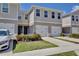 Townhome exterior with painted facade, white garage door, black hardware, and landscaped front yard at 421 Sedgewick Dr, Davenport, FL 33837