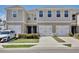 Townhome exterior with painted facade, white garage door, black hardware, and landscaped front yard at 421 Sedgewick Dr, Davenport, FL 33837