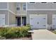 Townhome exterior with painted facade, white garage door, black hardware, and landscaped front yard at 421 Sedgewick Dr, Davenport, FL 33837
